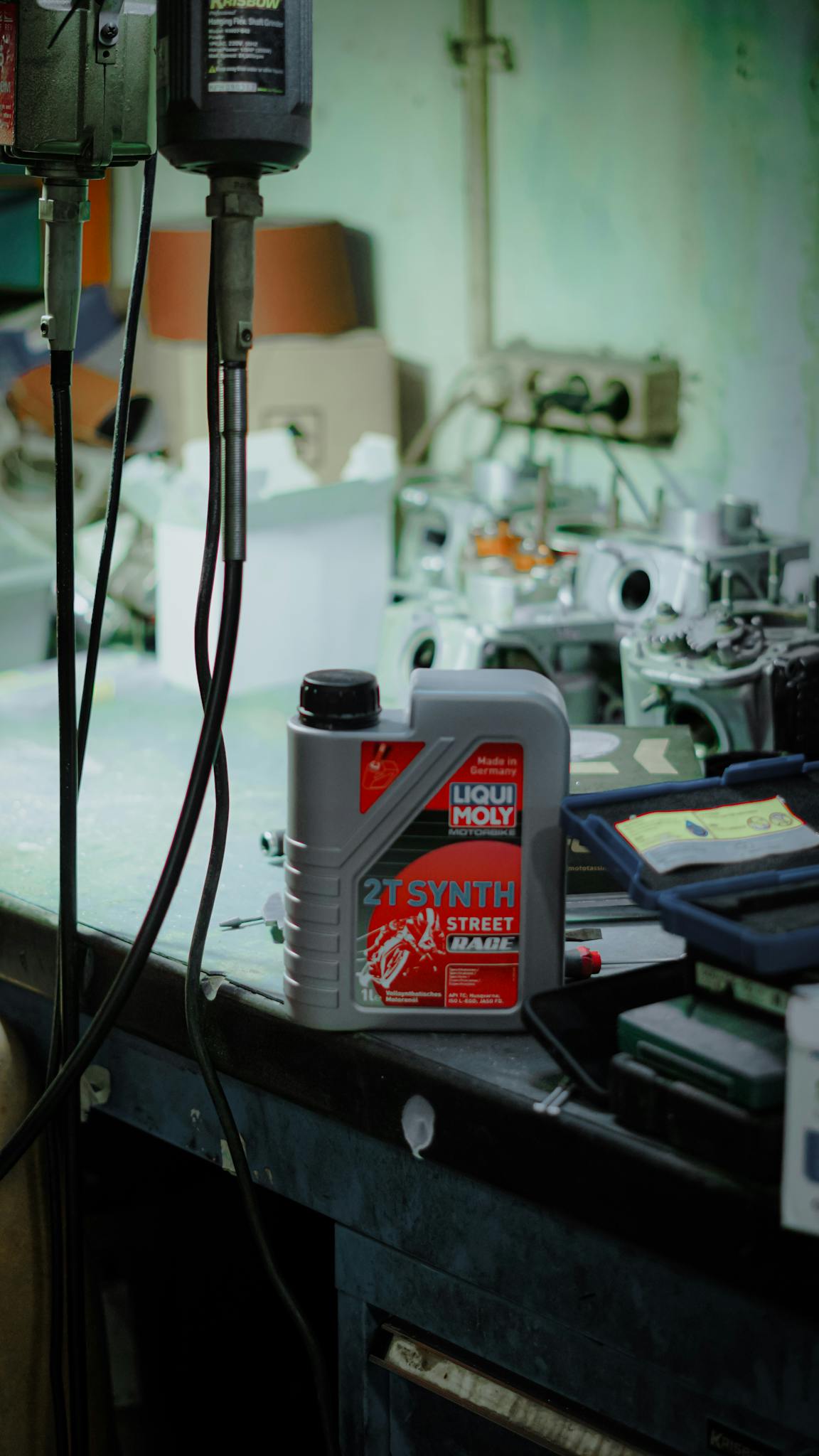 Motorbike maintenance workshop featuring Liqui Moly oil container in Jakarta, Indonesia.